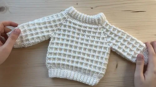 Waffle stitch baby sweater with V stitch corners